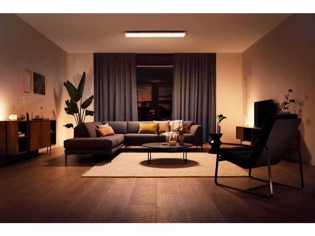 Plafón rectangular Philips Hue Aurelle iluminando un salón con una luz cálida durante la noche