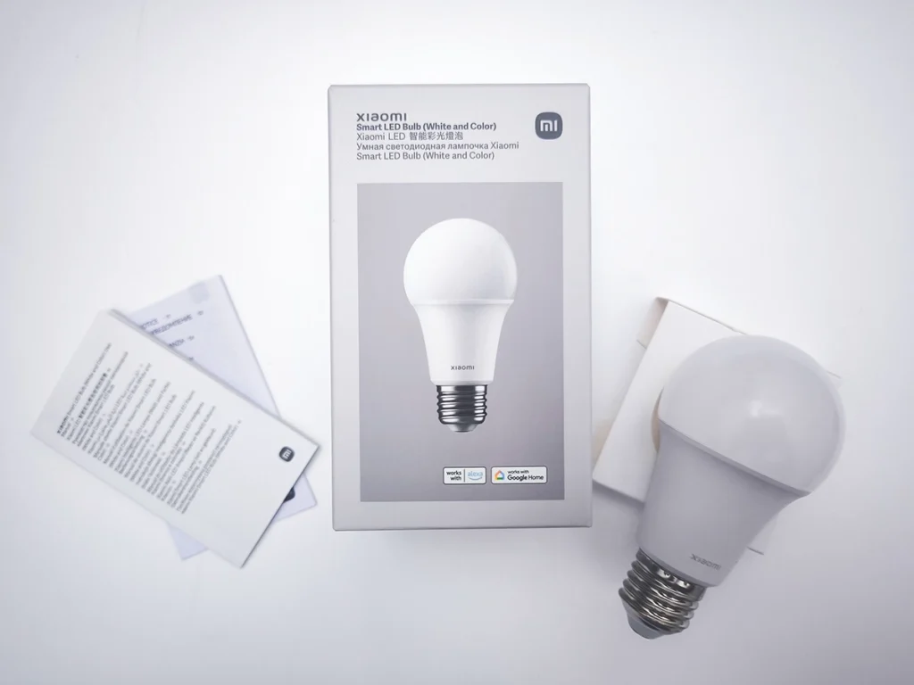 Contenido de la caja de la bombilla Xiaomi Smart LED Bulb (White and Color), mostrando el producto real, su embalaje oficial y el manual de usuario.