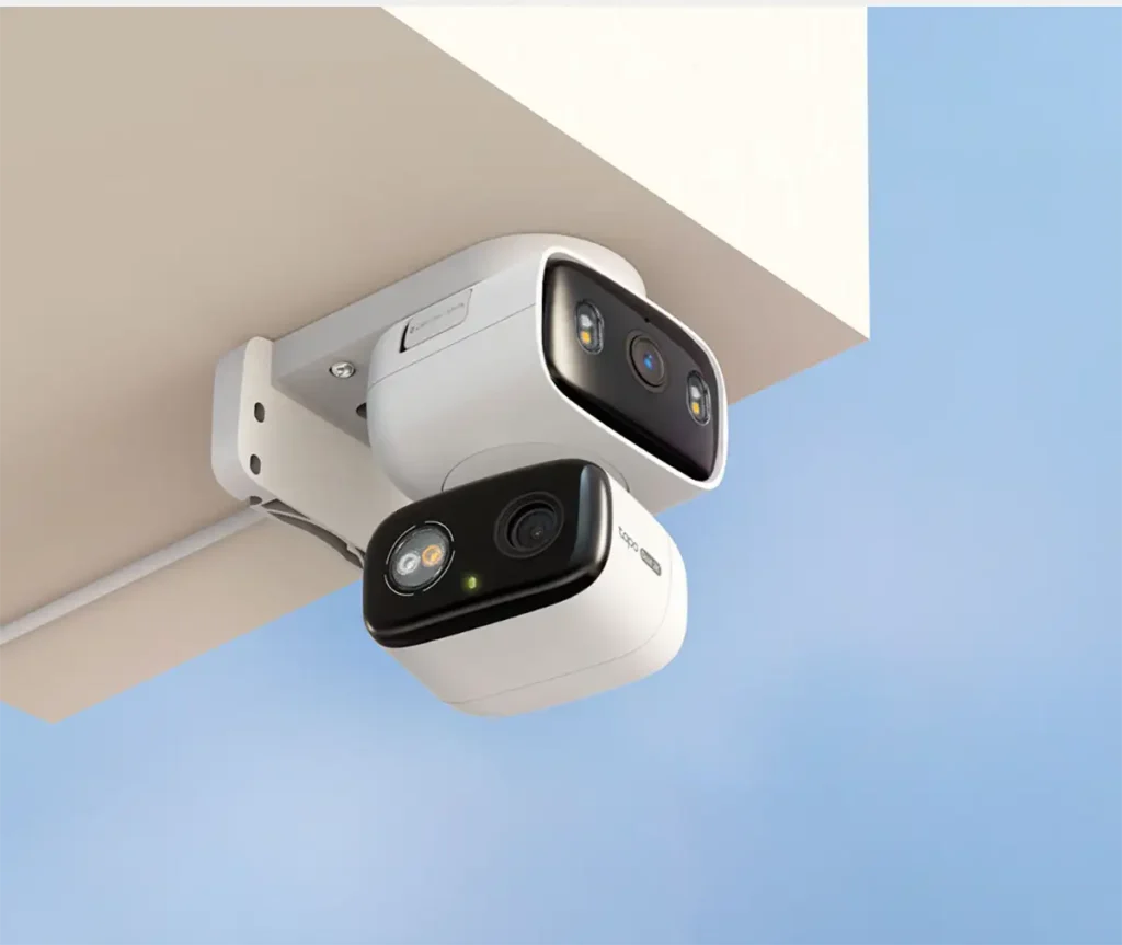 Imagen de la cámara de seguridad blanca TP-Link Tapo C246D montada en un techo, destacando su sistema de doble lente 2K, uno fijo y otro motorizado, para vigilancia exterior.
