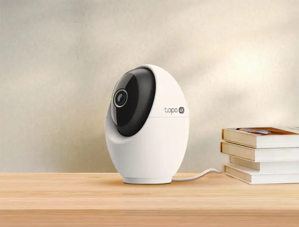 Imagen de la cámara de interior Tapo C260 con resolución 4K y modo de privacidad, mostrando su diseño compacto en color blanco sobre un escritorio de madera.
