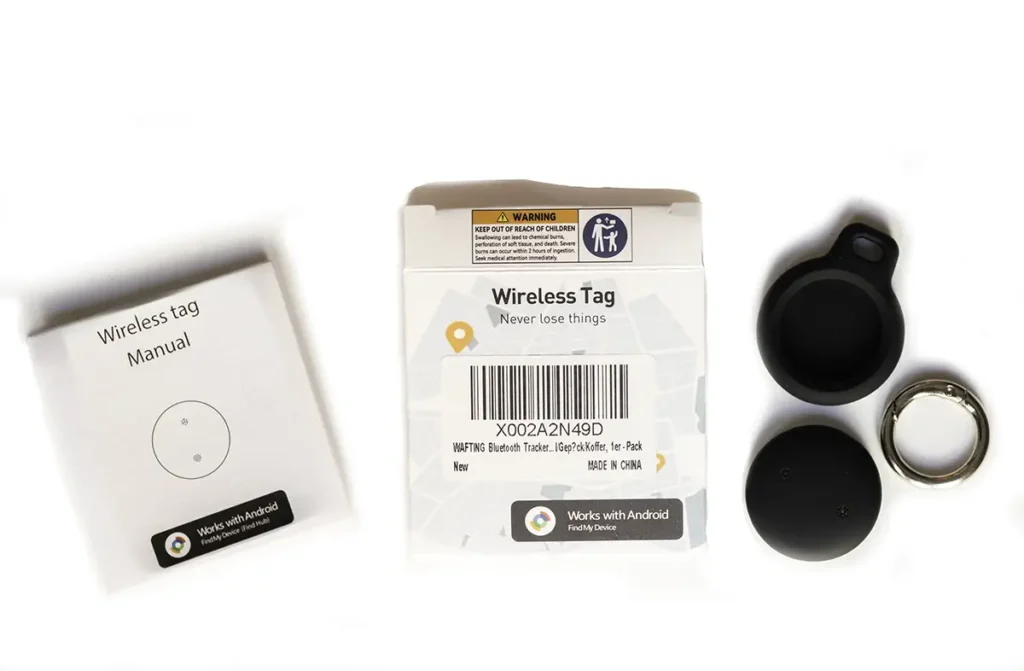 Contenido del paquete del localizador WAFTING Tracker Tag sobre una superficie blanca, mostrando el manual, la caja con logos de 'Works with Android', el dispositivo desmontado, una funda de silicona negra y una anilla para llavero.