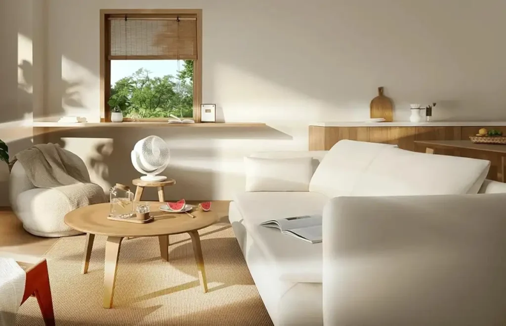 El ventilador Xiaomi Smart Desktop Air Circulation Fan en un salón moderno y luminoso, mostrando su diseño compacto y portátil sobre una pequeña mesa de madera.