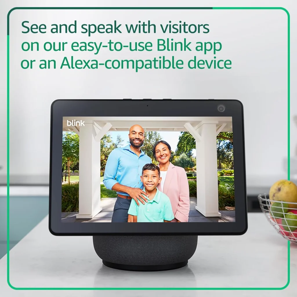 Un dispositivo Amazon Echo Show mostrando la imagen en directo de una cámara Blink. En la pantalla se ve a una familia sonriendo, demostrando la integración con Alexa para ver y hablar con los visitantes.