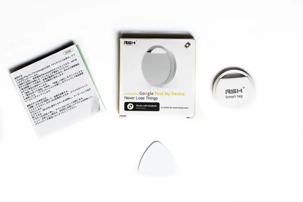 Contenido de la caja del localizador Bluetooth RSH Track Tag compatible con la red Encontrar mi dispositivo de Google. En la imagen se ven el smart tag, el manual, la caja y la herramienta de apertura.