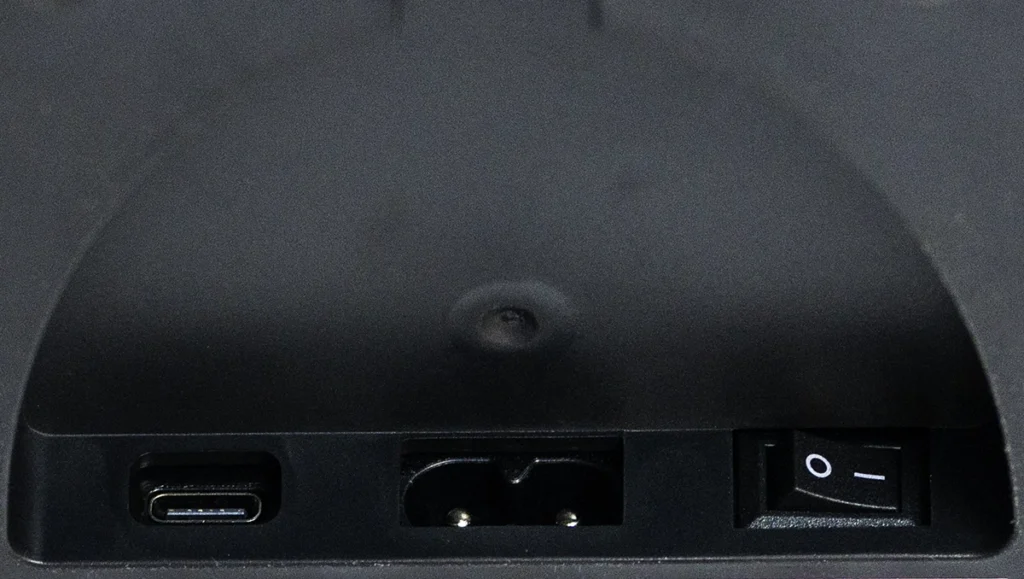 Detalle de los puertos de conexión y encendido en la base del ventilador SwitchBot Battery Circulator Fan. Se observa el puerto de carga USB-C, el conector para el cable de alimentación principal y el interruptor físico de encendido y apagado.