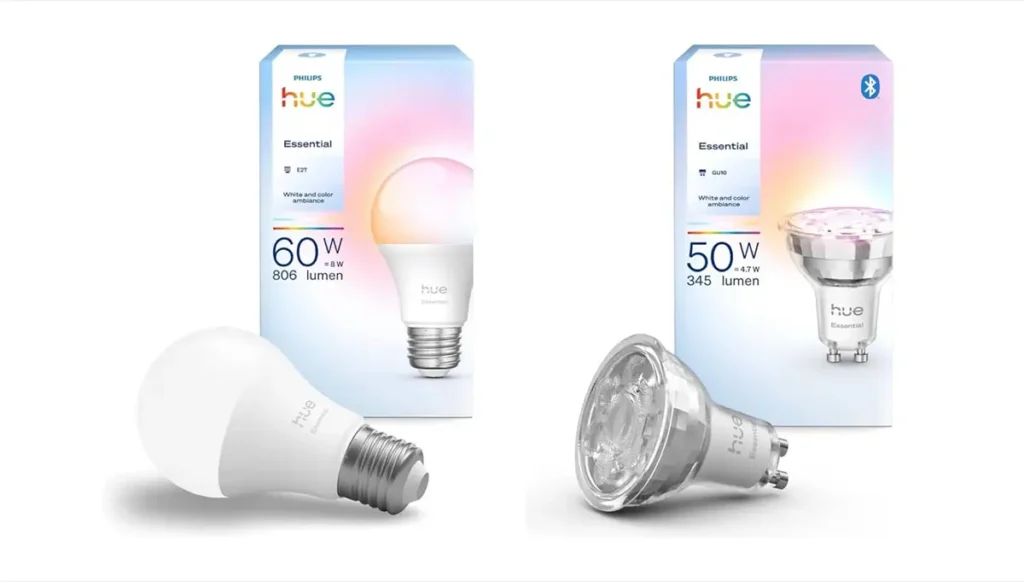 Imagen comparativa de las bombillas inteligentes Philips Hue Essential con sus cajas. A la izquierda, el modelo White and color ambiance con casquillo E27 de 806 lúmenes. A la derecha, el foco GU10 de 345 lúmenes, ambos de la nueva gama de entrada.