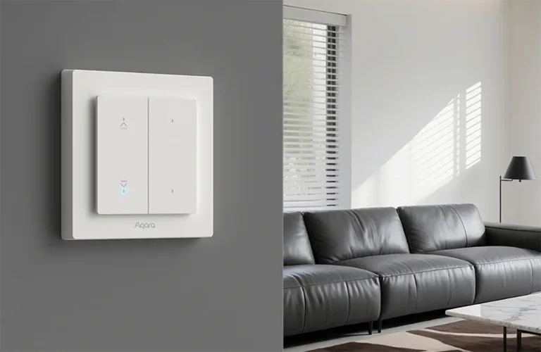 El interruptor de persiana inteligente Aqara Shutter Switch H2 EU instalado en la pared de un salón moderno. Su diseño minimalista en blanco controla las persianas del fondo y ofrece conectividad dual Thread y Zigbee para una integración perfecta en el hogar inteligente