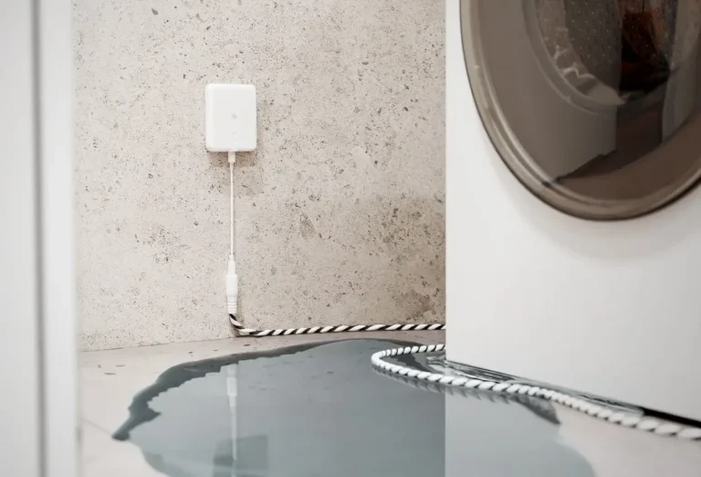 Imagen de portada del detector de fugas de agua Shelly Flood Gen4, mostrando cómo su cable sensor detecta una inundación o fuga de una lavadora. Un sensor de domótica para la seguridad del hogar conectado, compatible con Matter, Zigbee y Wi-Fi.