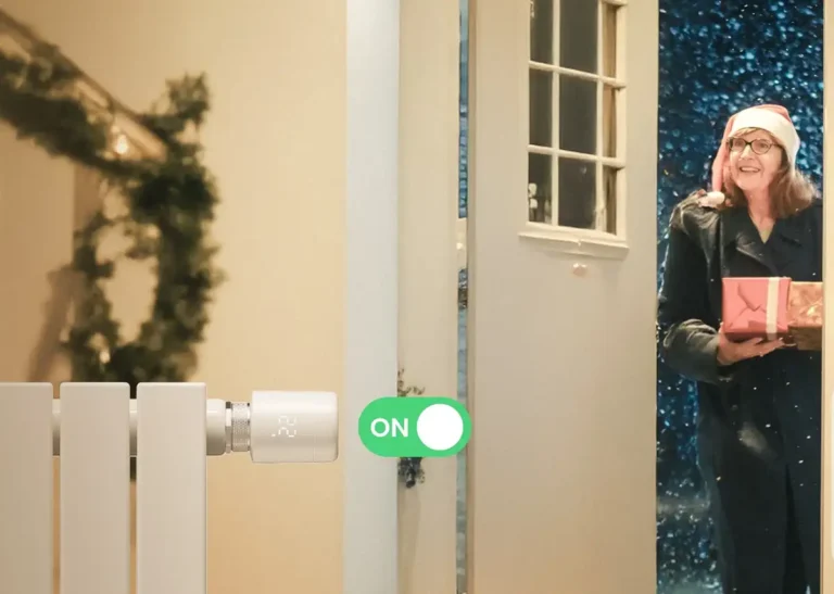 Demostración de la función de geovalla (geofencing) del Termostato Inteligente SwitchBot. Una mujer llega a casa en una noche de invierno y el termostato enciende automáticamente la calefacción para darle la bienvenida a un hogar cálido y confortable, optimizando el ahorro energético.