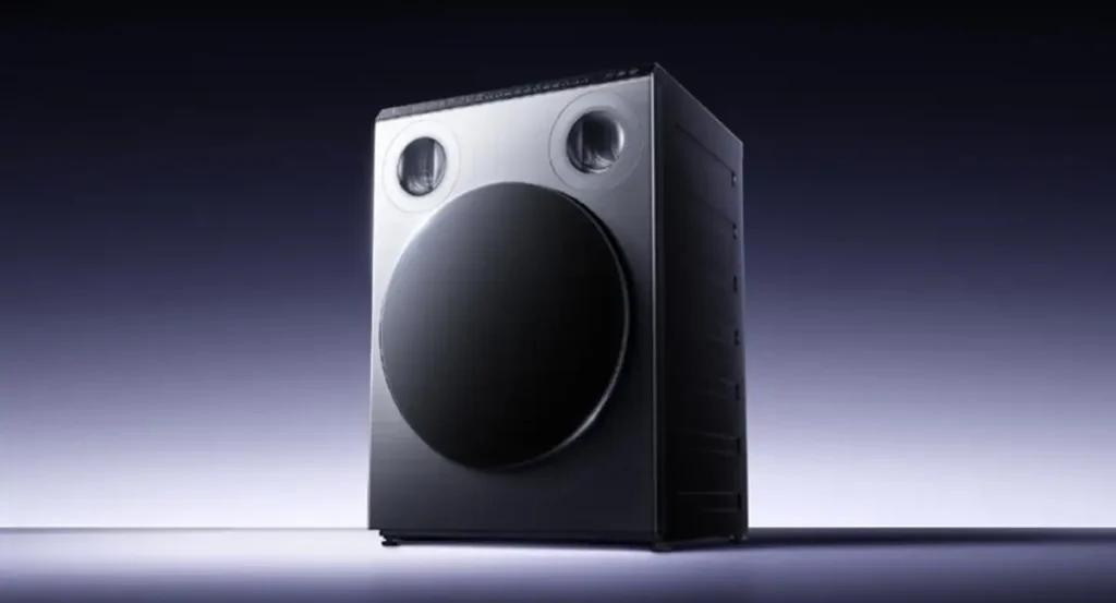 Imagen de estudio de la lavadora de tres zonas Xiaomi Mijia Three-Zone Washing Machine Pro, mostrando su innovador diseño de triple tambor de carga frontal. El electrodoméstico inteligente tiene un acabado metálico oscuro y un aspecto futurista sobre un fondo degradado.