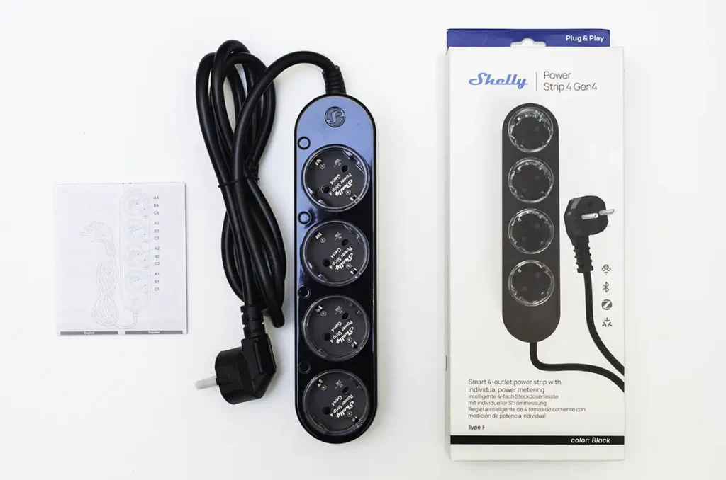 Análisis y unboxing de la Shelly Power Strip 4 Gen4, la regleta inteligente definitiva para domótica local. En la imagen se muestra el contenido completo del paquete, con la regleta de 4 tomas con medidor de consumo individual, su manual y el embalaje. Este dispositivo destaca por su triple conectividad (Wi-Fi, Zigbee y Matter), siendo ideal para una integración avanzada con Home Assistant a través de Zigbee2MQTT o MQTT. Su diseño en color negro, los botones físicos por toma y la protección contra sobretensión la convierten en una solución robusta y versátil para cualquier escritorio o salón.