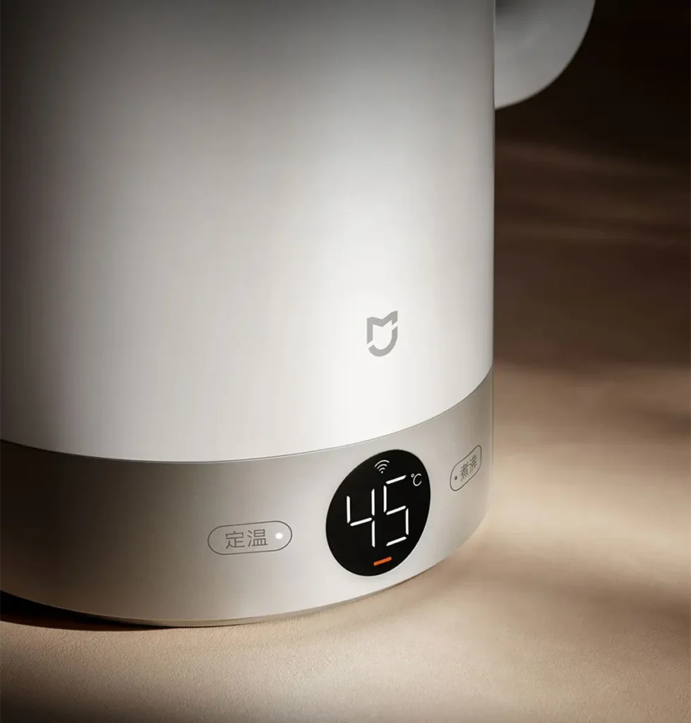Primer plano de la base del hervidor inteligente Xiaomi Mijia Kettle 3 Pro. La pantalla LED circular muestra la temperatura a 45°C y el icono de conexión Wi-Fi. Se aprecian los botones táctiles de control para mantener la temperatura y hervir