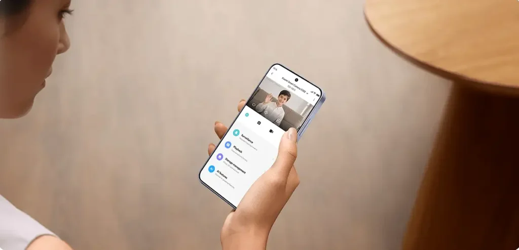 Demostración de la aplicación Xiaomi Home para gestionar la cámara Xiaomi Smart Camera C302. La interfaz muestra la transmisión de vídeo en directo en 2K y el menú de acceso a funciones clave como el audio bidireccional, la revisión de grabaciones (Playback), la gestión del almacenamiento y la configuración de las alertas por IA.