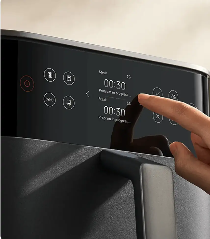 Mano sosteniendo un smartphone que muestra la app Xiaomi Home con más de 100 recetas en la nube para la freidora de aire inteligente. En la pantalla se ve un recetario visual con platos como pollo, pescado y verduras, listo para el control inteligente de la cocción.
