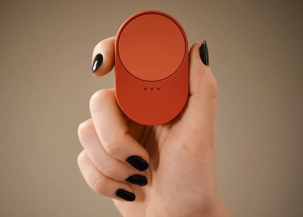 Mano sosteniendo el nuevo mando a distancia inteligente IKEA BILRESA en color rojo, uno de los controles físicos compatibles con Matter para gestionar luces y escenas en el ecosistema de hogar conectado DIRIGERA.