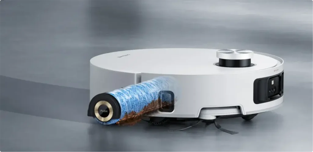 Primer plano del robot fregasuelos Dreame Aqua10 Roller con su rodillo de limpieza azul extendido lateralmente para eliminar la suciedad acumulada en el borde del suelo, demostrando su función de fregado de bordes.