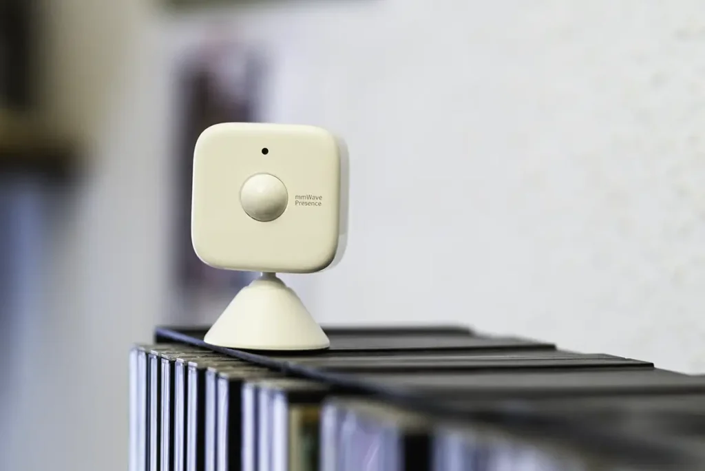Sensor de presencia SwitchBot con radar mmWave colocado sobre una estantería, ideal para domotizar habitaciones y baños