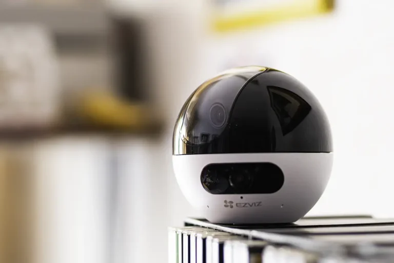 Análisis de la cámara Ezviz C7 Dual de doble lente con soporte RTSP. La cámara de vigilancia, en color blanco y negro, sobre una superficie en un entorno doméstico.