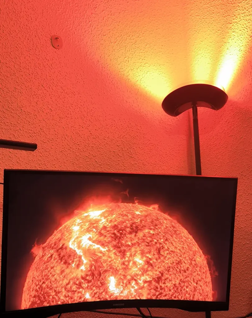 Lámpara de pie Govee Torchiere sincronizada con la pantalla del PC mediante Govee Desktop DreamView, reproduciendo tonos rojos y naranjas de una escena del sol.