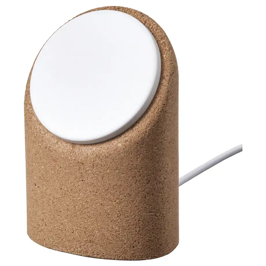 Cargador inalámbrico IKEA VÄSTMÄRKE con soporte de corcho, base inclinada y disco blanco de carga con cable.