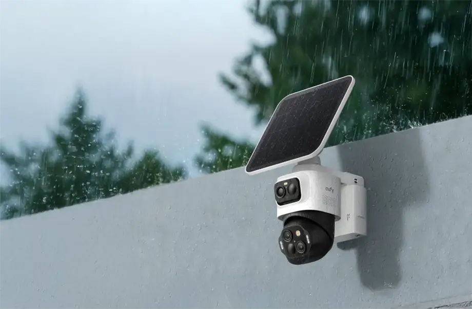 Cámara de seguridad eufyCam S4 con panel solar montada en una pared exterior bajo la lluvia, mostrando su resistencia IP65