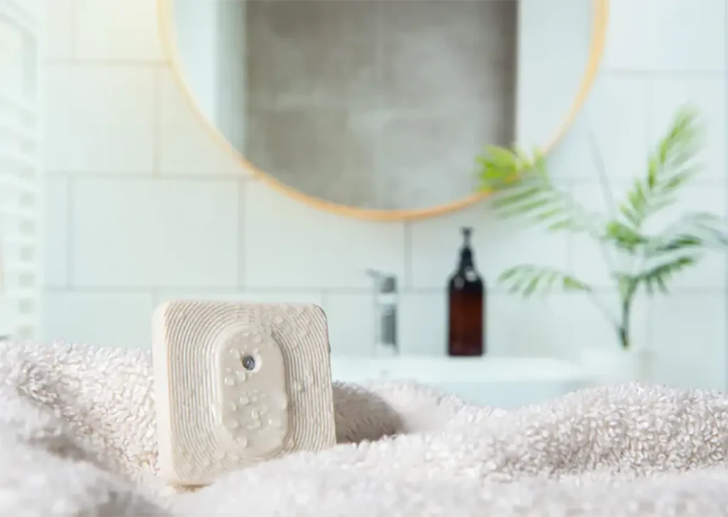 Shelly BLU H&T ZB Ivory en un baño, sensor inteligente de temperatura y humedad con Bluetooth y Zigbee y protección IP54