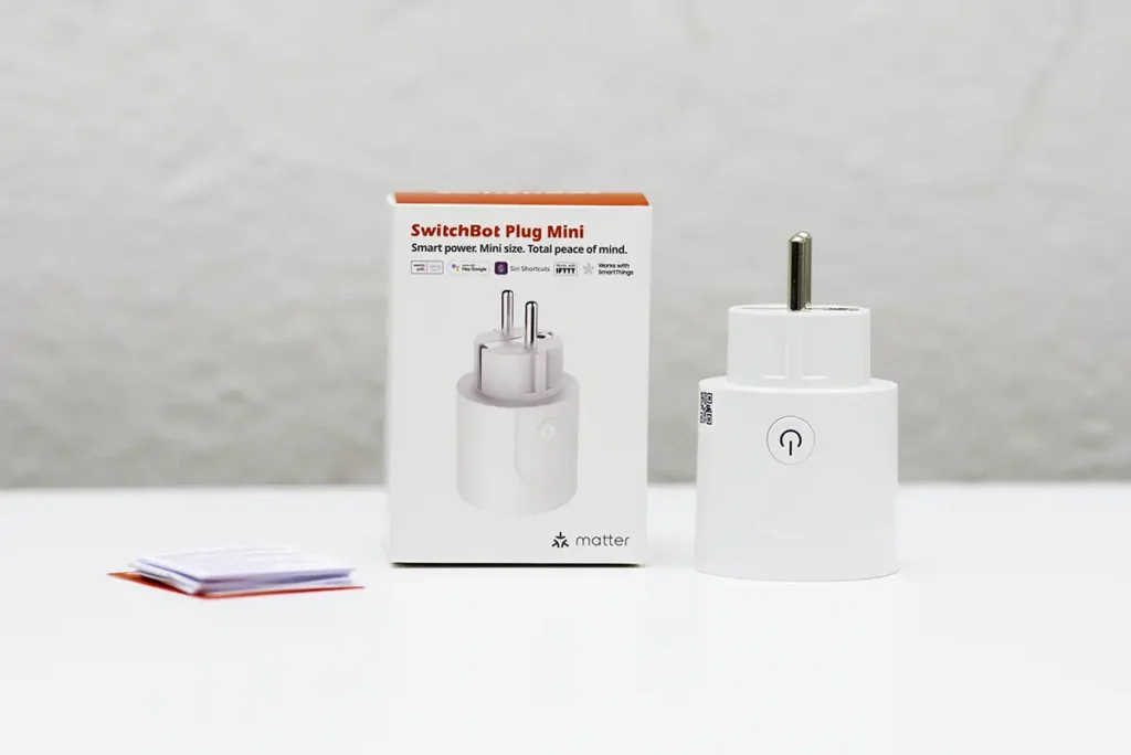 SwitchBot Plug Mini EU junto a su caja y manual, enchufe inteligente Wi-Fi con Matter