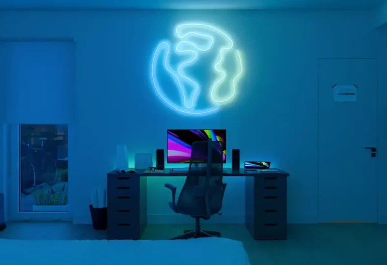 Philips Hue Basis Flex iluminando una pared con efecto neón azul y verde en un escritorio de oficina, creando luz ambiental en interior.