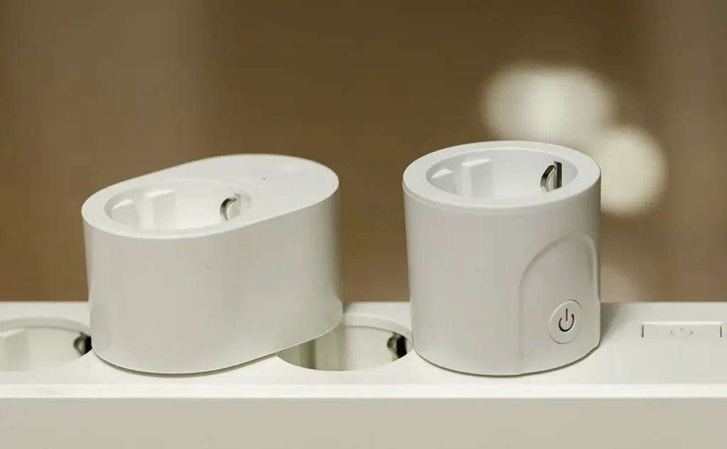 Comparativa del Xiaomi Smart Plug 2 y un enchufe compacto en una regleta para mostrar el espacio que ocupan