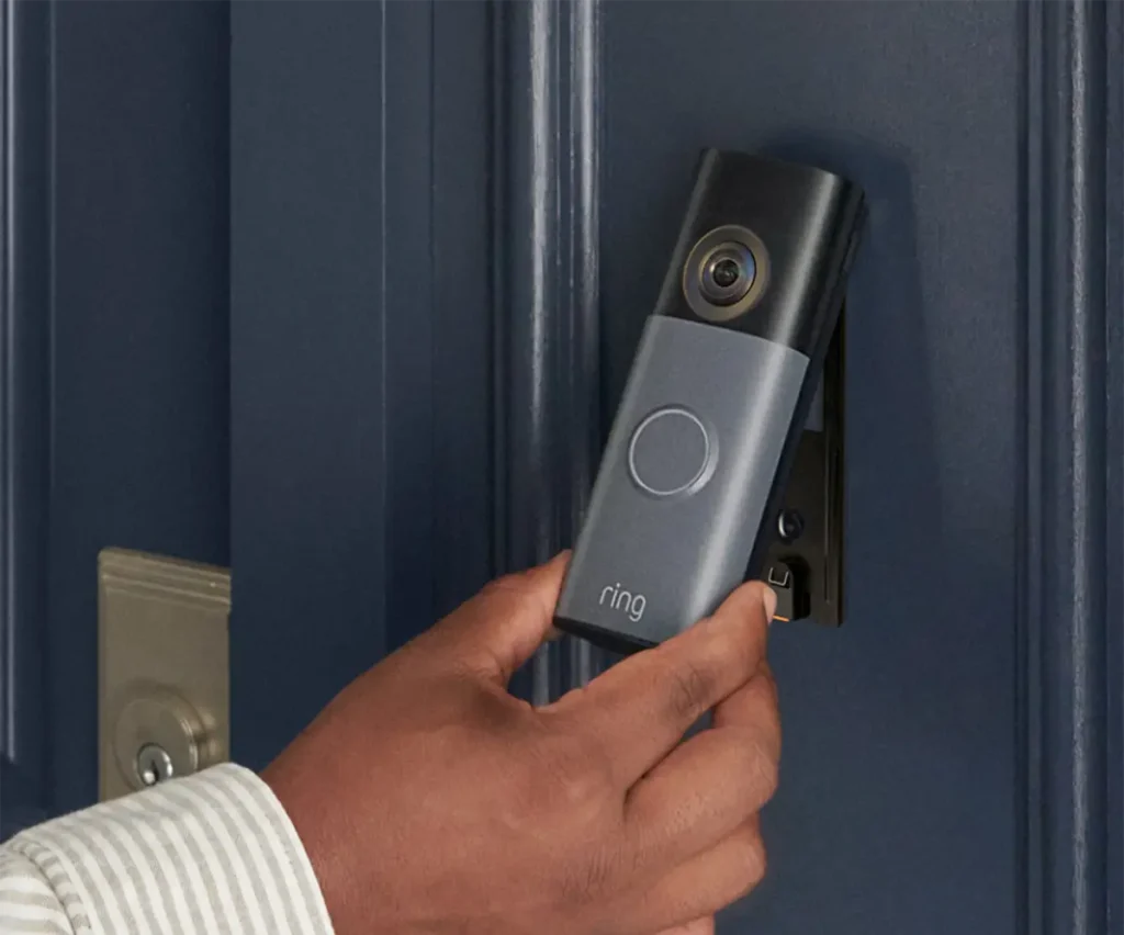 Persona retirando un videotimbre Ring con batería de su soporte para recargarlo