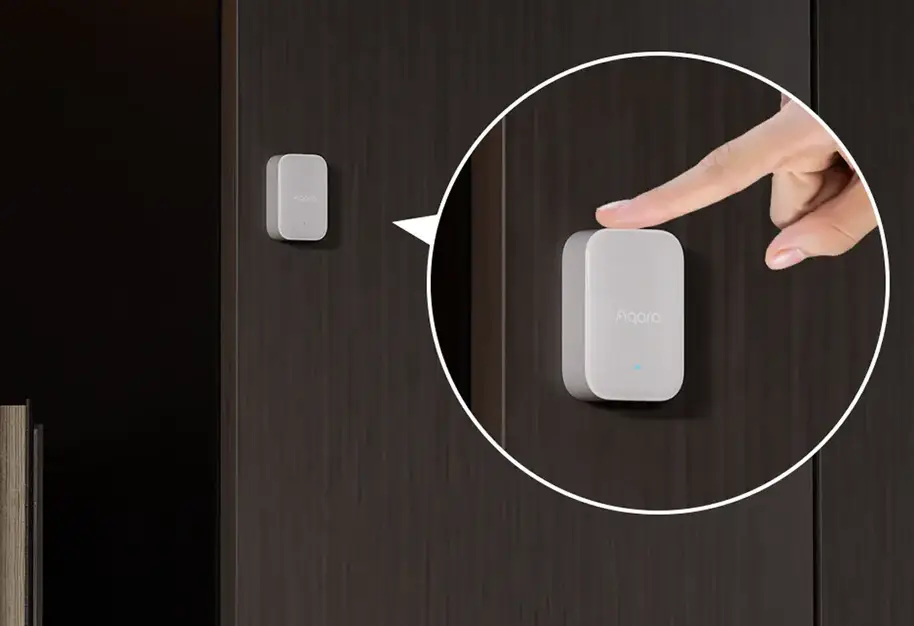 Detalle del Aqara Sensor Multiestado P100 instalado en una puerta, con ampliación de la calibración manual sobre el dispositivo