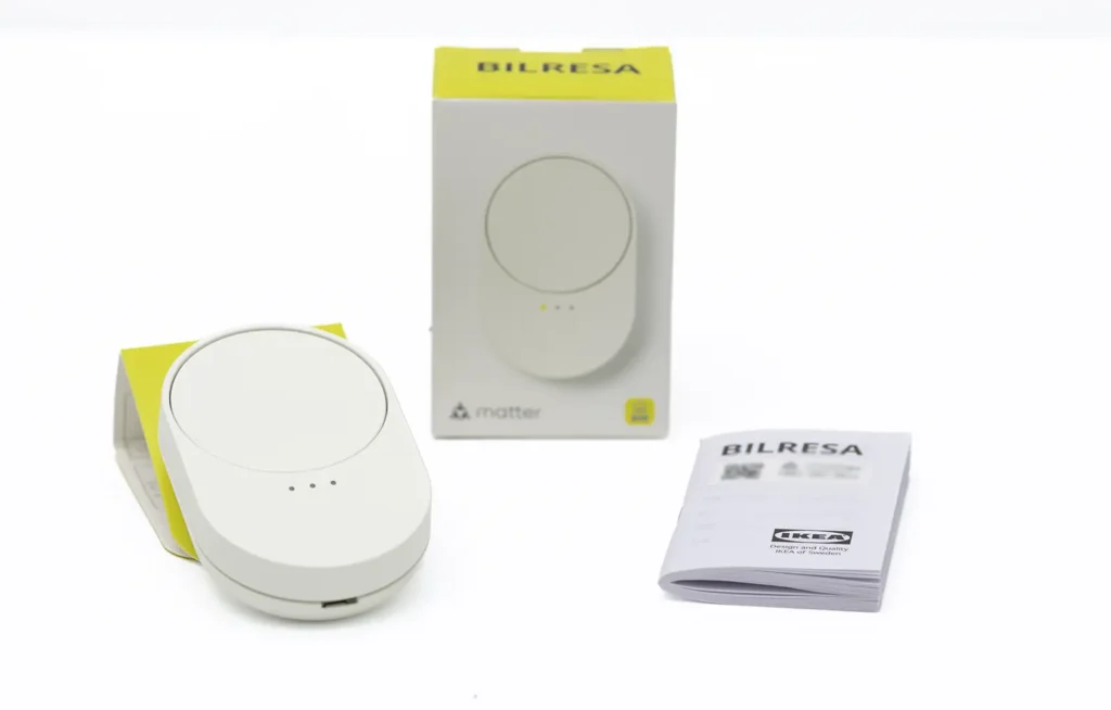 Unboxing del IKEA BILRESA Scroll Wheel con el mando, la caja y el manual sobre fondo blanco