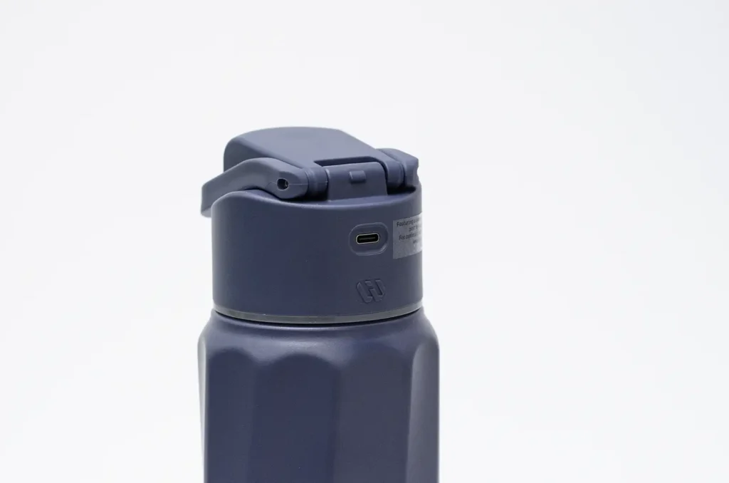 Puerto de carga USB-C sin tapa protectora en la parte trasera de la tapa de la botella WaterH Boost