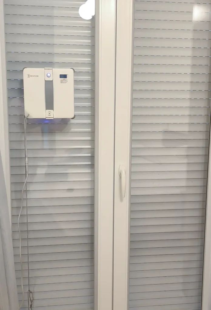 ECOVACS WINBOT Mini 2 limpiando una ventana vertical estrecha del piso