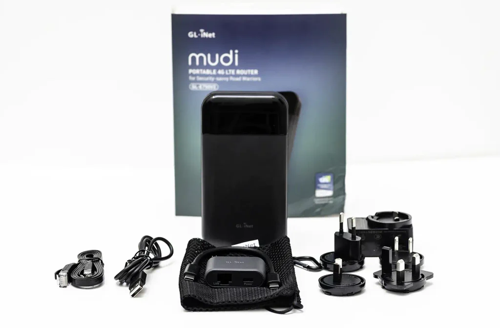 Contenido de la caja del GL.iNet Mudi V2: router, caja, bolsa de transporte, cargador con cabezales intercambiables, cables y replicador USB-C con puerto RJ45