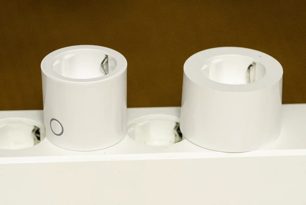 Comparativa de tamaño entre el Aqara Power Plug H2 EU y el Aqara Smart Plug EU SP-EUC01 enchufados en una regleta