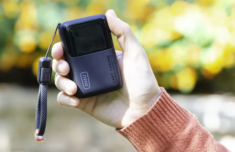 INIU Pocket Rocket P50 sujeta en la mano, una batería externa de 10.000 mAh y 45 W tan pequeña que cabe en la palma, con pantalla digital y cable USB-C de cordón