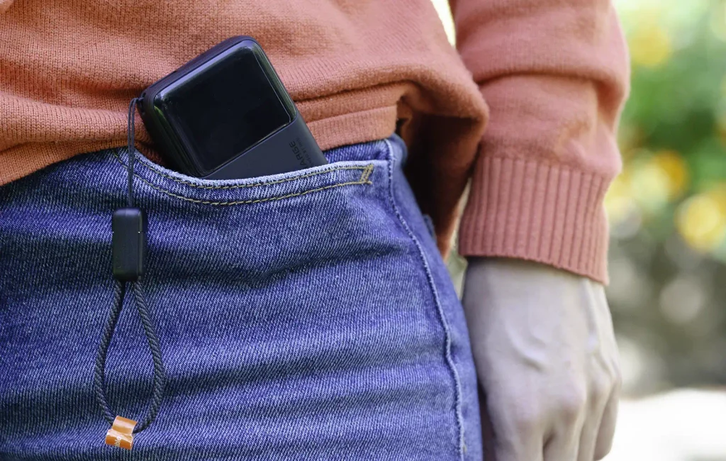 INIU Pocket Rocket P50 guardada en el bolsillo de un pantalón vaquero con el cable de cordón colgando